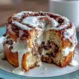 Warm cinnamon swirl protein bagels topped with a creamy vanilla Greek yogurt glaze, perfect for a protein-packed breakfast or snack.  