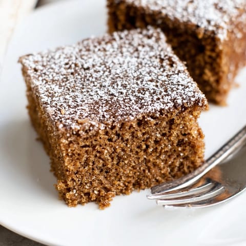 A square of moist Cinnamon Gingerbread Snack Cake, ready to be served with coffee.
