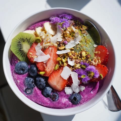 Colorful Vibrant Smoothie Bowls with Unexpected Twists, featuring kiwi and edible flowers.  