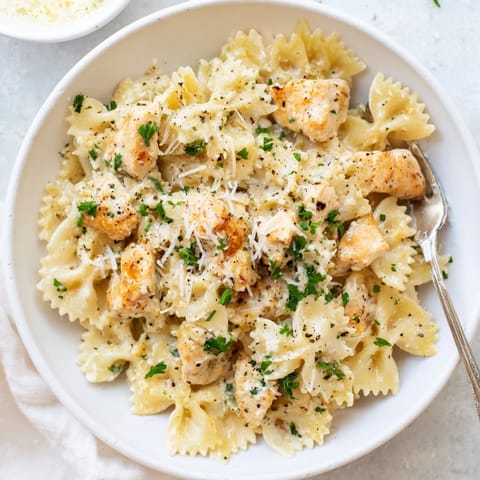 Creamy garlic butter sauce coats bowtie pasta and juicy chicken pieces.  