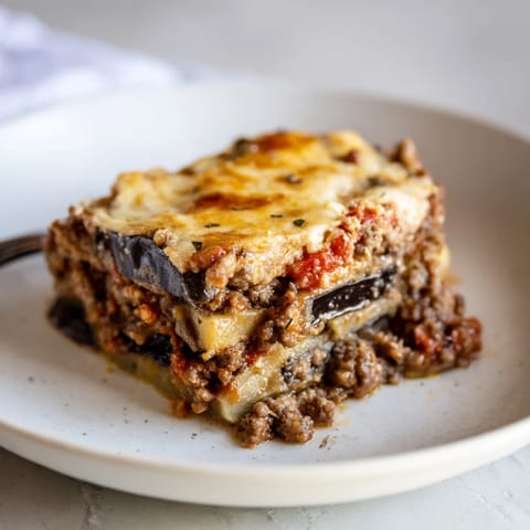A hearty serving of moussaka with beef and eggplant, perfect for family dinners.  