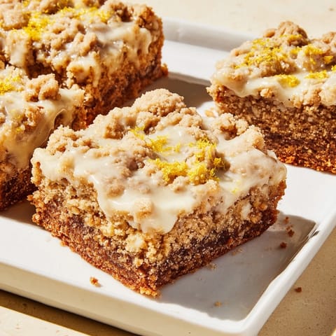 Tempting square of lemon-glazed gingerbread crumble bars, spiced aroma rising with a buttery crumble detail.