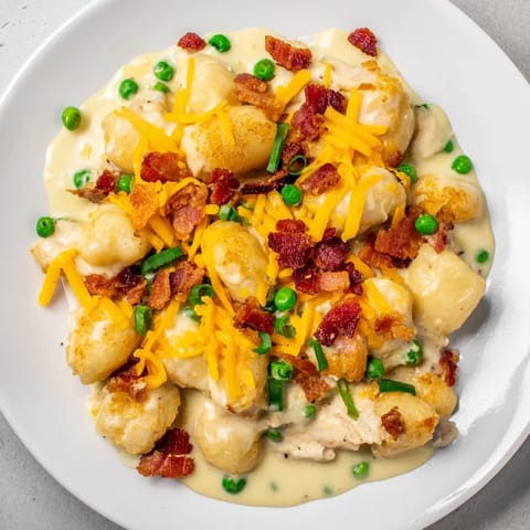 A hearty bowl of Creamy Crack Chicken Gnocchi, showcasing tender chicken with bacon and peas.