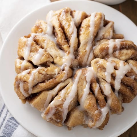 A generously iced cinnamon roll pull-apart snowflake, perfect for sharing and enjoying warm with your coffee.