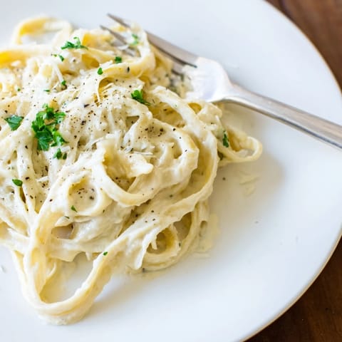 Plated Easy Creamy Cauliflower Alfredo with al dente linguine and a light, velvety sauce for a low-fat main.