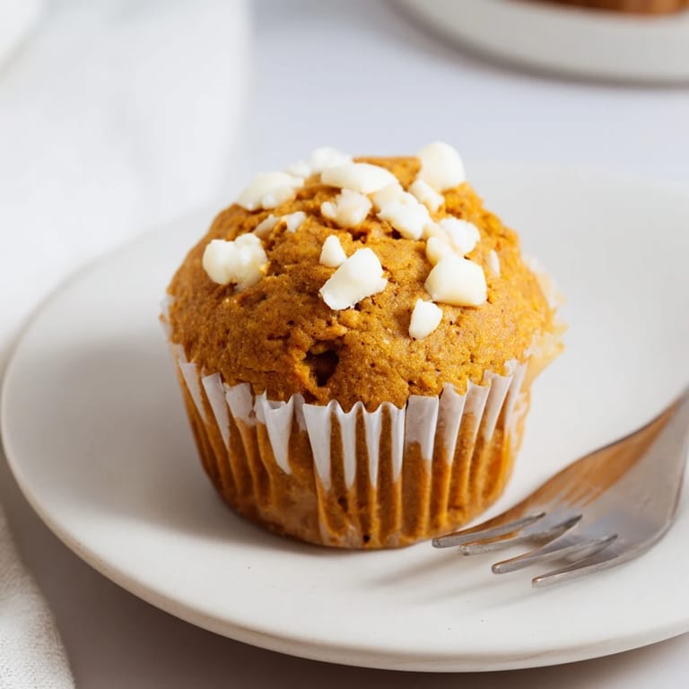 Delicious pumpkin muffins loaded with creamy white chocolate chunks for cozy mornings.  
