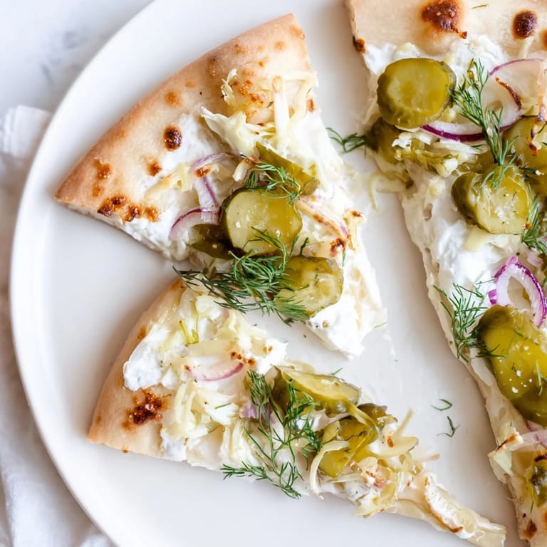 Satisfy cravings with this unique Pickle Pizza, garnished with fresh dill and onions.