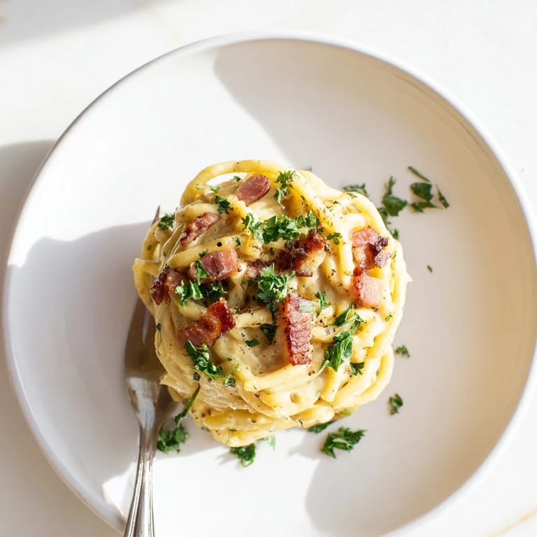A delicious bowl of Carbonara Ramen Fusion, featuring perfectly cooked ramen and flavorful Parmesan cheese.
