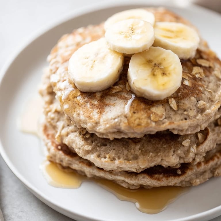 Close-up of freshly cooked banana oat pancakes, showcasing their soft, textured surface.