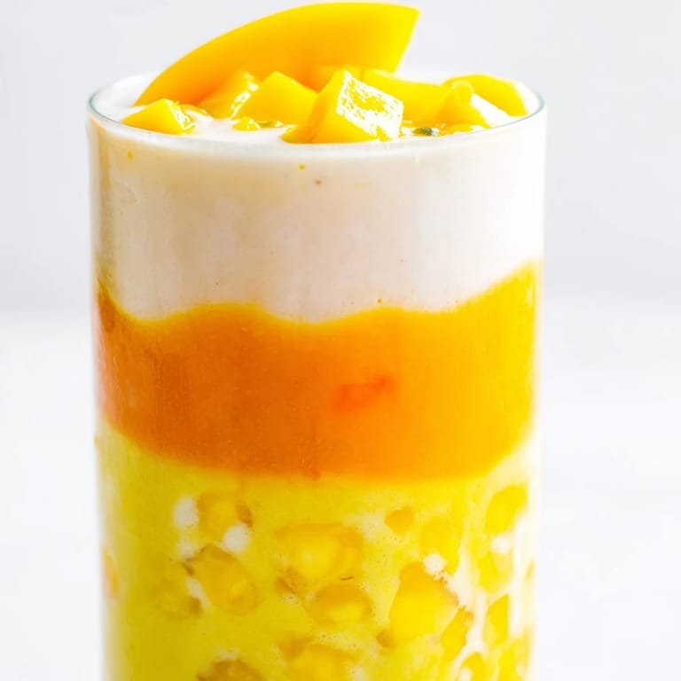 This bright Tropical Sunset Smoothie features three colorful layers, perfect for a healthy and delicious summer treat.