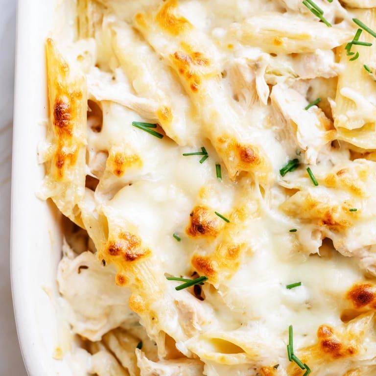 A close-up of the creamy Chicken Ranch Pasta Bake, featuring tender chicken and penne pasta covered in melted cheese.